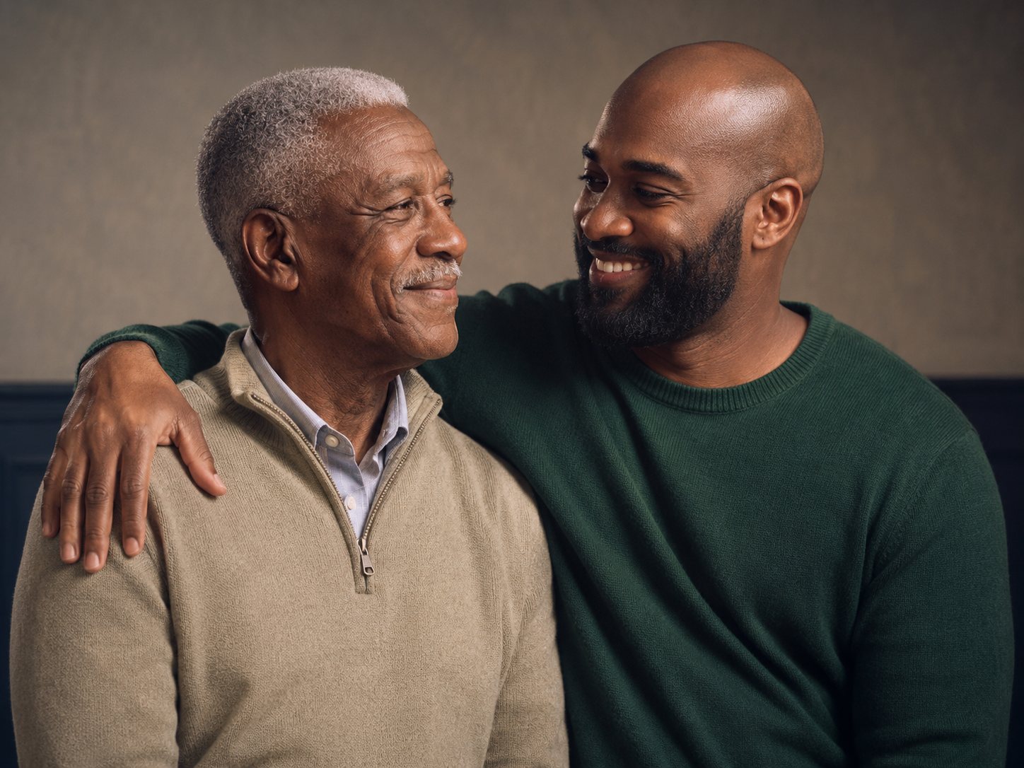 An older man and his adult son, arm around him.