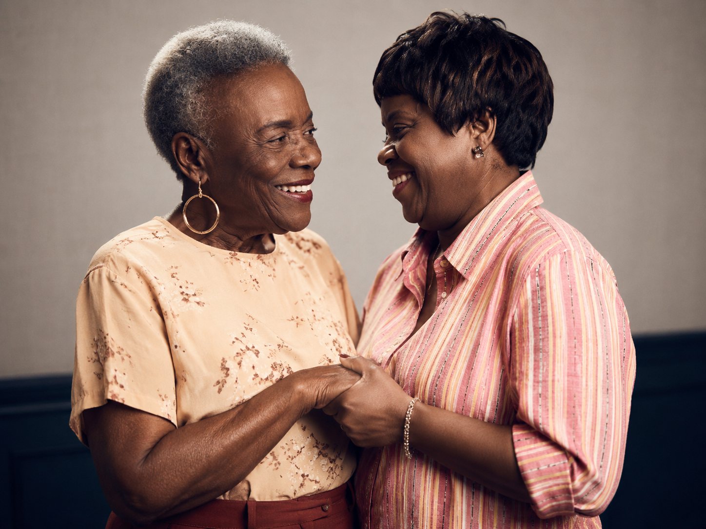 Two older women embracing and laughing.