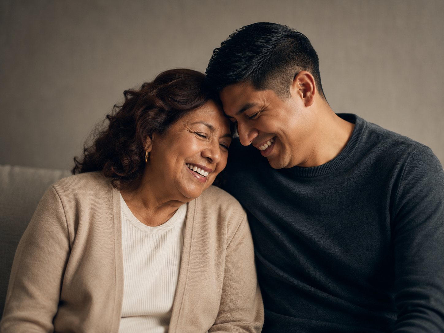 An older father and adult son smiling together.