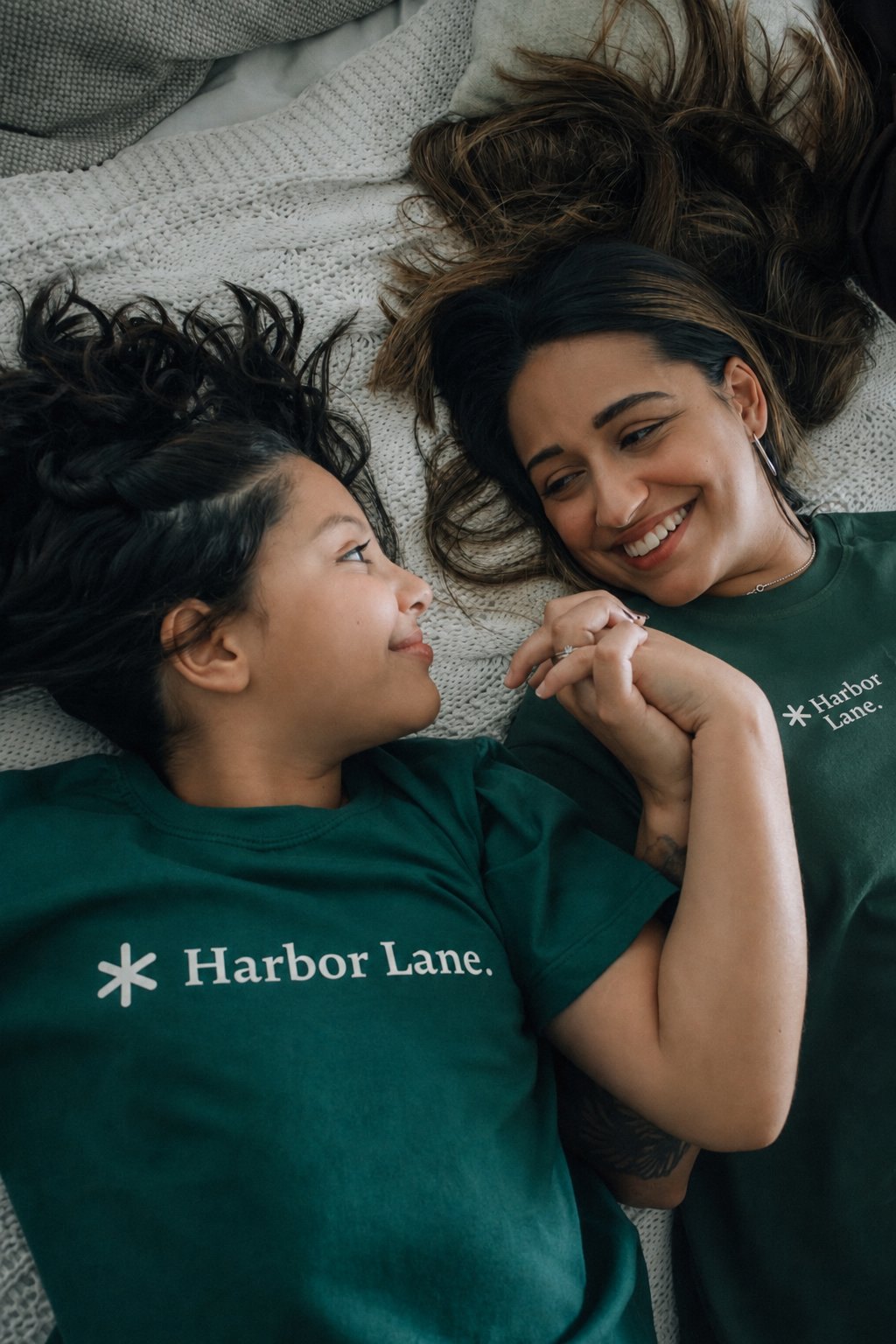 Two family members laughing together in Harbor Lane shirts.