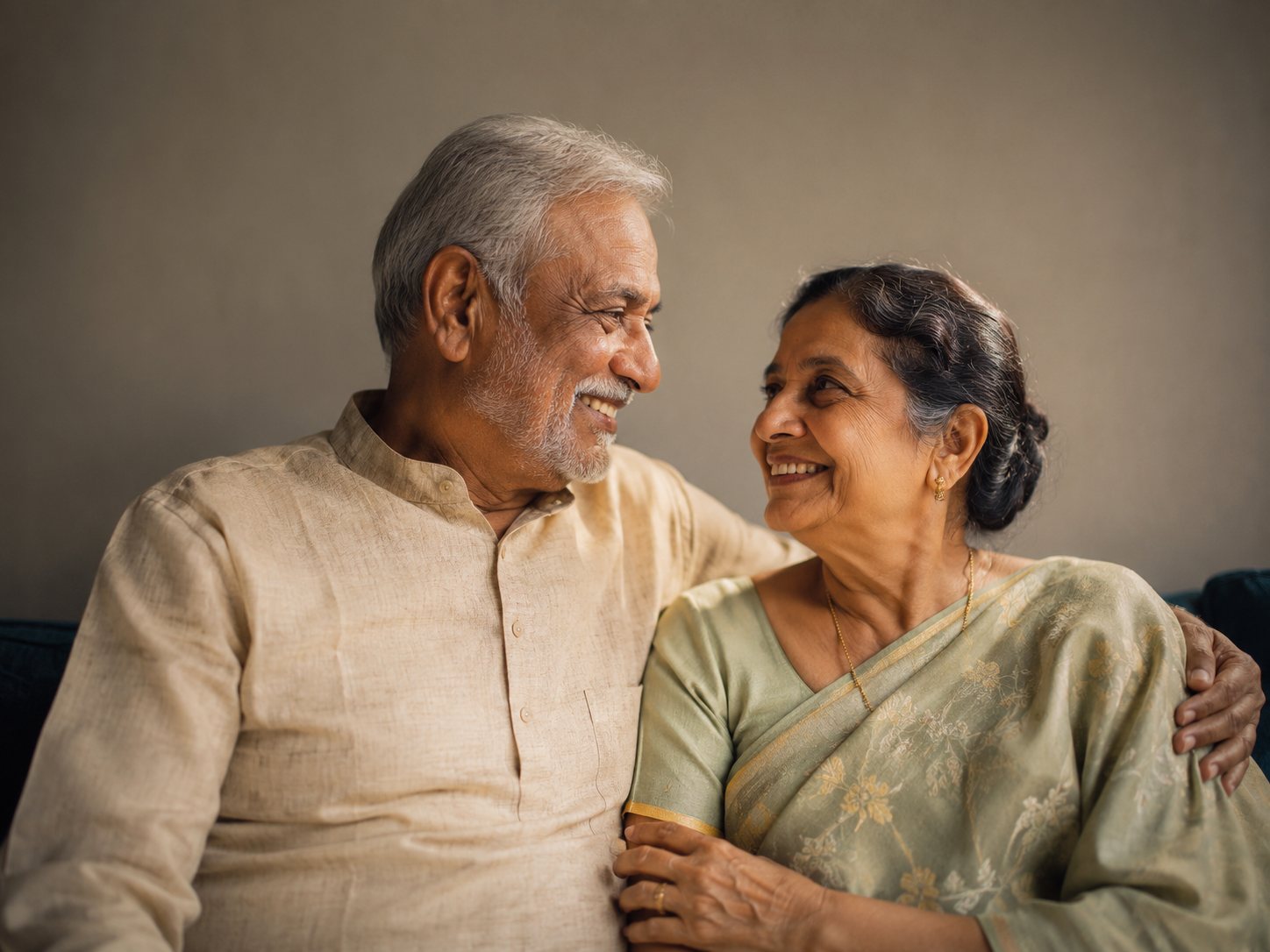 An older couple sitting together, relaxed and smiling.