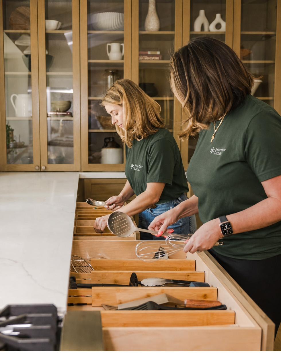 Harbor Lane team members organizing drawers in a client's new kitchen.