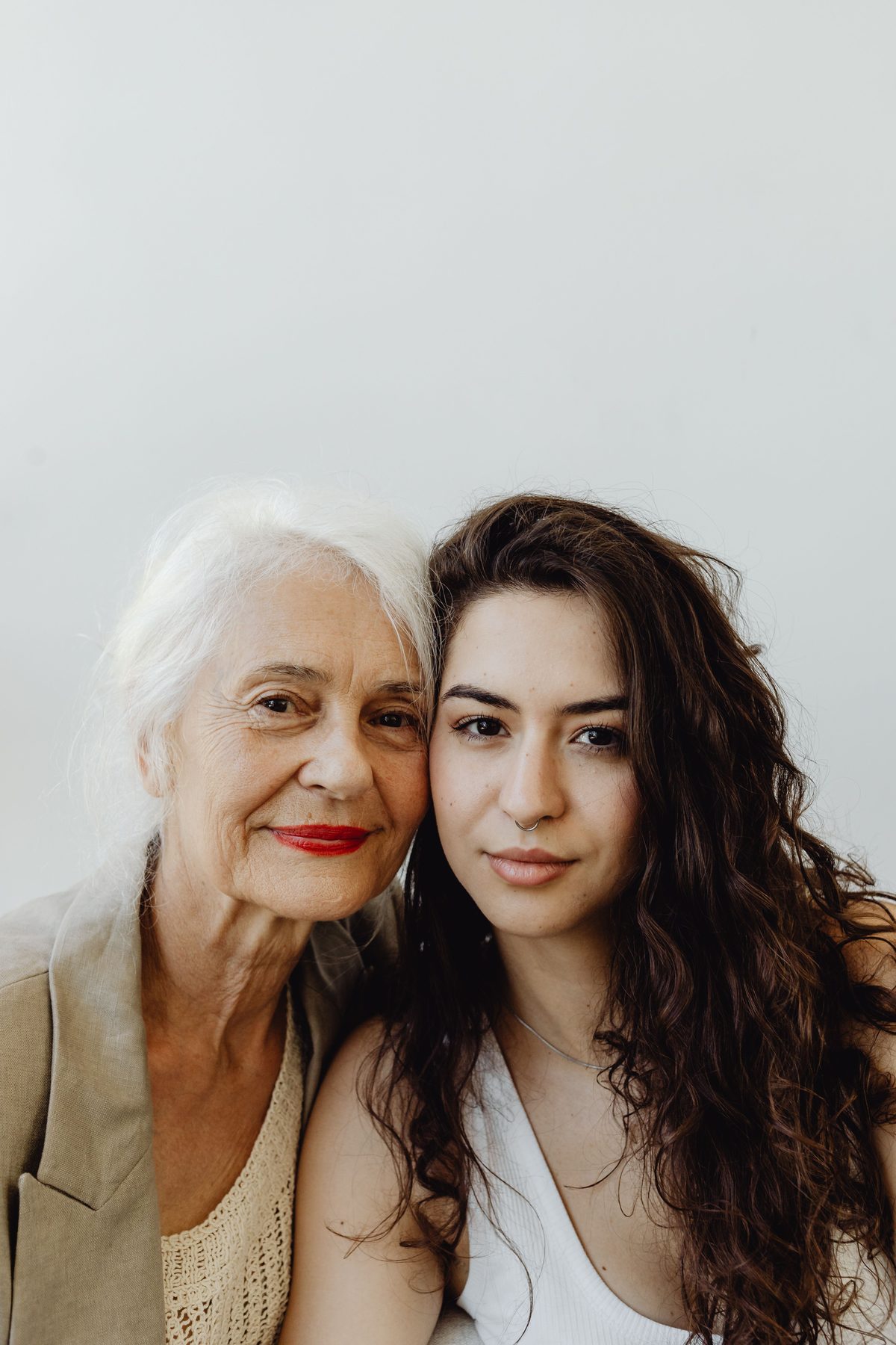 A grandmother and her granddaughter sitting close together, smiling.